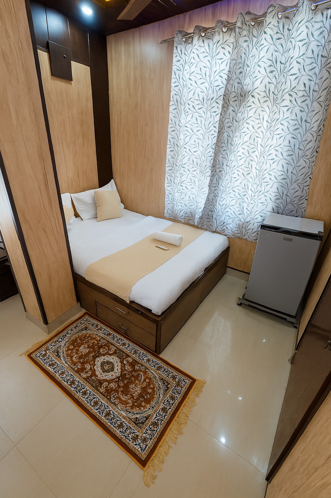Dev Hotel Mansarovar classic room with clean bed and mini fridge